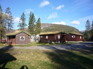 un granero con techo de hierba y patio en Tosbotn Camping & Cottages en Tosbotnet