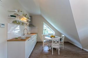 uma cozinha com um lavatório e uma mesa num quarto em Green Hill Guest House em Berkovitsa