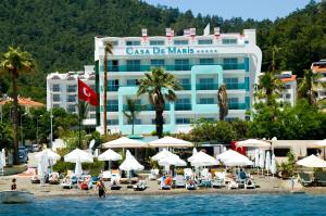 a hotel on a beach with chairs and umbrellas at Casa De Maris Spa & Resort Hotel Adult Only 16 Plus in Marmaris