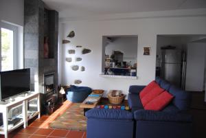 ein Wohnzimmer mit blauen Sofas und einem Fernseher in der Unterkunft Casa da Malta in Livramento