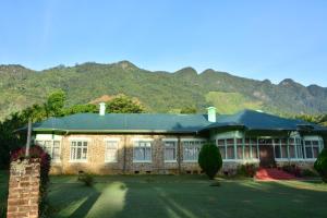 un grande edificio in mattoni con le montagne sullo sfondo di Morris Bungalow a Passara