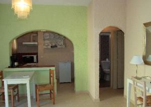 a kitchen and dining room with a table and chairs at Perla Apartments in Agia Pelagia