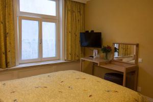 - une chambre avec un lit, une fenêtre et une télévision dans l'établissement Hotel Imperial, à Amsterdam