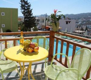 une table jaune avec un bol de fruits sur un balcon dans l'établissement Perla Apartments, à Agia Pelagia