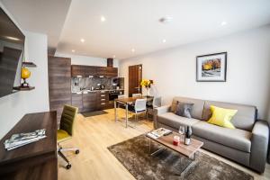 ein Wohnzimmer mit einem Sofa und einem Tisch in der Unterkunft Hampton Suites Serviced Apartments in Kingston upon Thames