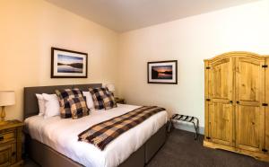 a bedroom with a bed and a dresser at Inch Hotel in Fort Augustus
