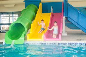 2 bambini che giocano su uno scivolo in piscina di Crows Nest Caravan Park a Filey