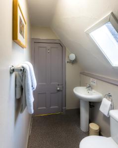 a bathroom with a toilet, sink and mirror at Inch Hotel in Fort Augustus