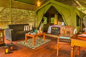 a living room with a tent with a couch and a table at Ahaspokuna by Eco Team in Belihul Oya