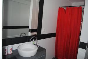 ein Badezimmer mit einem Waschbecken und einem roten Duschvorhang in der Unterkunft Casa da Malta in Livramento + 50 Fotos