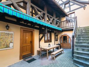 un edificio con mesa, bancos y escaleras en Gîtes de la Maison Vigneronne, au Coeur de Ribeauvillé, en Ribeauvillé