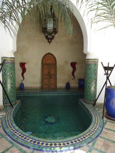 a swimming pool in a building with a house at Riad Tahar Oasis in Marrakesh