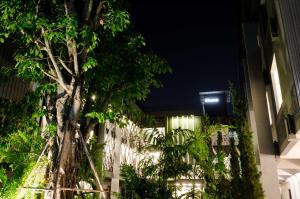 a building with a light on the side of it at night at Shane Hotel in Chiang Mai