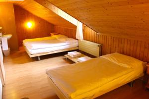 a room with two beds in a wooden cabin at Hôtel - Restaurant Le Trift in Zinal