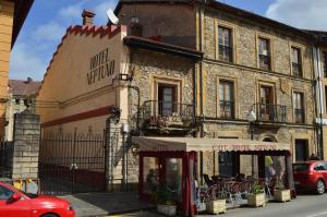 an old stone building with a restaurant on a street at Hotel Neptuno in Villaviciosa
