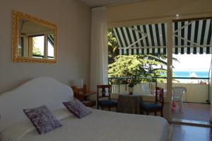 a bedroom with two beds and a table and a balcony at Hotel Broglia in Sirmione
