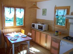 a small kitchen with a table and a microwave at Les Feuillantines in Saint-Genès-Champespe