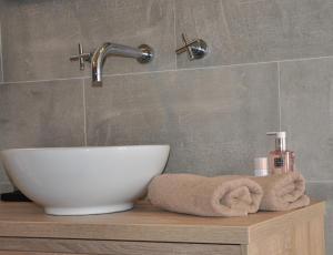 a bathroom with a sink and a faucet at De Slapende Leeuw in Middelburg +31 photos