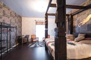 a bedroom with a four poster bed and a desk at Chambres d'hôtes & Gîtes La Paysanne in Fresnes-en-Woëvre