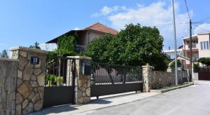 una cerca frente a una casa con una puerta en Apartment Julietta, en Pirovac