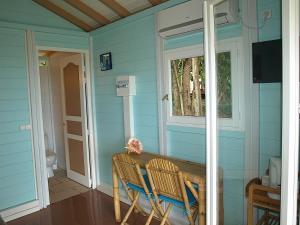 Casa azul con mesa y ventana en Coco D'Iles, en Terre-de-Bas