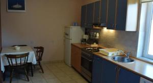 cocina con fregadero, fogones y mesa en Apartment Julietta, en Pirovac