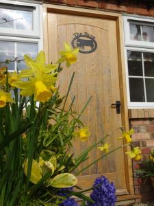a wooden door with yellow flowers in front of a house at Centre village 2 bedroom cottage - The Byre in Pewsey