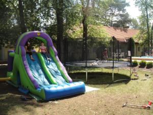 Eine Rutsche in einem Garten mit zwei Kindern drauf. in der Unterkunft Hotel Korona in Siófok