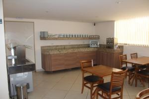a kitchen with a table and chairs and a counter at Itupeva Plaza Hotel in Itupeva