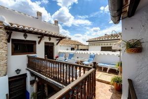 uma varanda com cadeiras azuis e uma mesa numa casa em Hotel Rural Tia Pilar em Almagro
