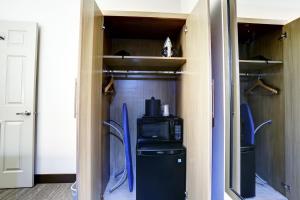 a walk in closet with a microwave and a refrigerator at GreenTree Pasadena in Pasadena
