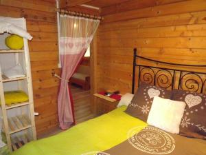 a bedroom with a bed in a log cabin at le chalet in Névy-lès-Dole