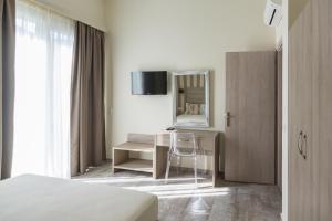 a bedroom with a bed and a desk and a mirror at Villas Marajo in Skala Potamias
