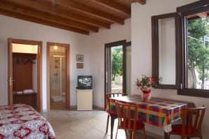 een kamer met een tafel en stoelen en een televisie bij Villa Giovanna in Nardò