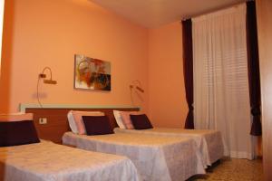a hotel room with two beds and a window at Hotel San Donnino in Fidenza