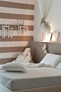 a bed with white sheets and pillows on it at Hotel Roma in Grottammare