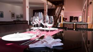 a table with wine glasses and plates on a table at Casa d´Edite in Chamusca