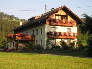 une maison avec des boîtes de fleurs devant elle dans l'établissement Ferienwohnungen Kolbitsch, à Greifenburg