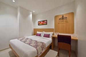 a hotel room with a bed and a desk and a bed sidx sidx at Hotel Leafio-Near Airport in Mumbai