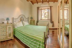 a bedroom with a bed with a green comforter at Casale Pratoterra in Bracciano