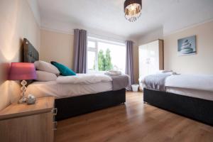 a bedroom with two beds and a window at Westfield House in Hinckley