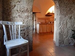 a white chair sitting in a room with a stone wall at B&B Noce Spagnola in Rocchetta a Volturno