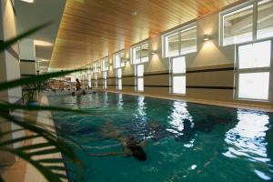 a swimming pool with people swimming in the water at Ensana Sovata in Sovata