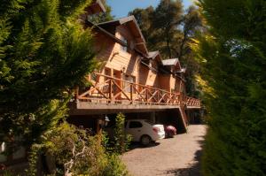 una casa con un coche aparcado delante de ella en Las Cumbres Apart & Suites en San Martín de los Andes
