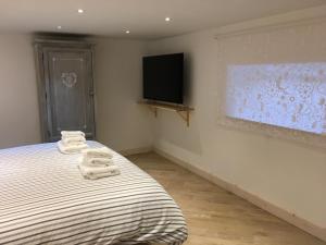 1 dormitorio con 2 toallas en una cama y TV en La Scalinata di Chiaia en Nápoles