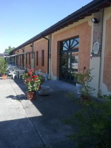 un edificio con un patio con flores delante en Le Magnolie Agriturismo en Verolanuova