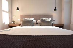 een slaapkamer met een groot wit bed met 2 kussens bij Lux Zadar No.6 in Zadar