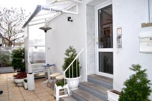 een veranda aan de voorzijde van een wit huis met planten bij Hotel Stern in Stuttgart