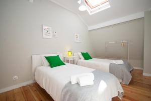 two beds in a room with green and white at Cosy Baixa Apartment in Lisbon