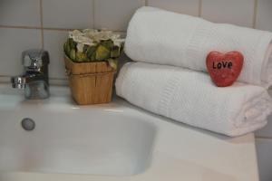 a bathroom sink with towels and a towel with the word love on it at Cosy Baixa Apartment in Lisbon +17 photos